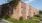 a brick building with a green lawn